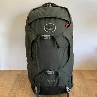 Osprey Farpoint 55, earlier version, standing upright on a wooden floor